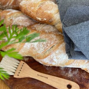 Brödpensel i trä och tagel tillsammans med nybakat bröd