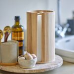 Hushållspappershållare i ljust trä från Bloomingville på köksbänk