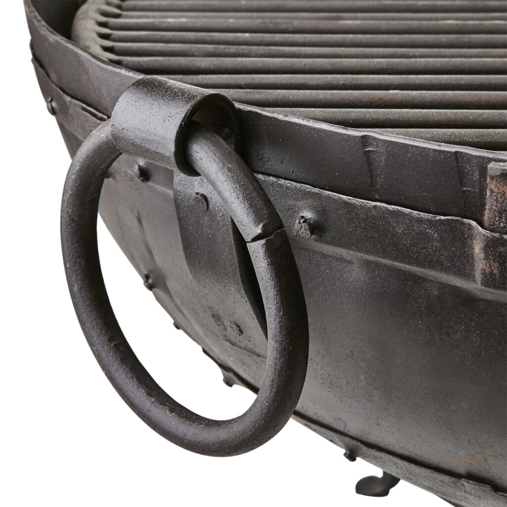 Detaljbild på eldkorg i järn med robust handtag och grillgaller.