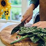 Närbild på ARBID skärbräda där en man skär palmkål.