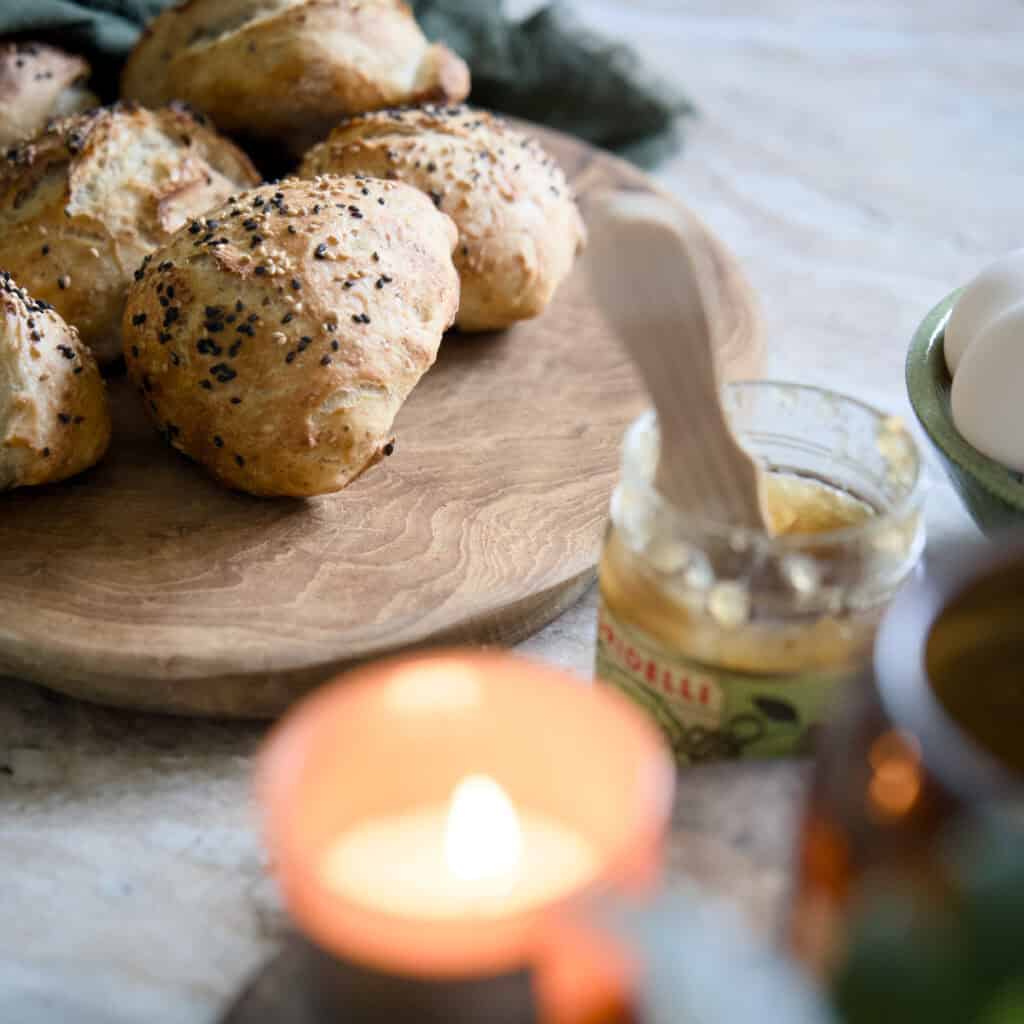 Rund skärbräda Arvid i teak från Affari of Sweden, serverad med nybakat bröd på frukostbord