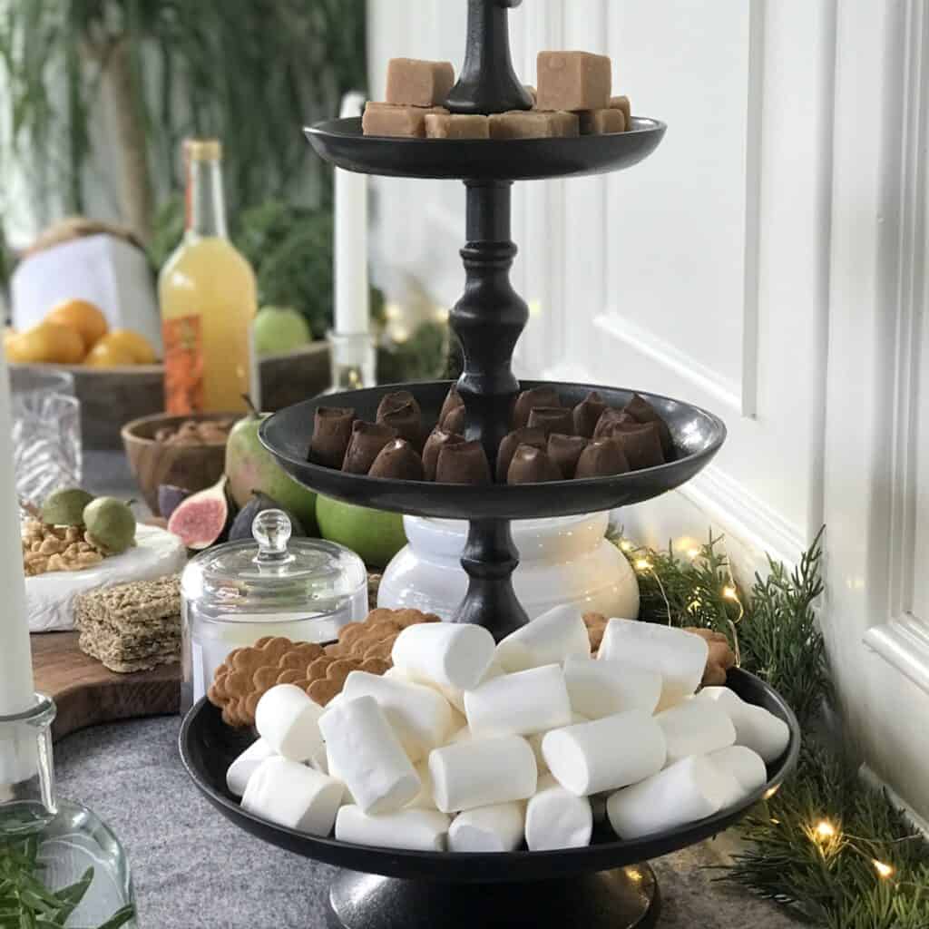 Kakfat i mörkbrun aluminium från Affari of Sweden, fyllt med godis och kakor i tre våningar på ett juligt dukat bord.