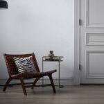 Porto fåtölj i stor storlek i teak och flätat läder i konjakston i stilren inomhusmiljö