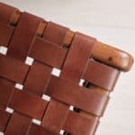 Närbild på flätad lädersits i konjak och teakram från Porto pall av Wikholm Form.