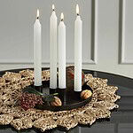 Bordstablett Doory från Nordal dekorerad med en svart ljusstake med fyra tända vita ljus och nötter.