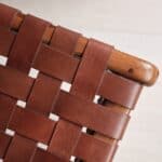 Närbild på flätat konjaksfärgat läder och trädetaljer på fåtöljen PORTO från Wikholm Form, som visar det hantverksmässiga utförandet och den robusta kvaliteten.