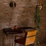 Vägglampa i mässing Corridor monterad på tegelvägg i varm inredningsmiljö