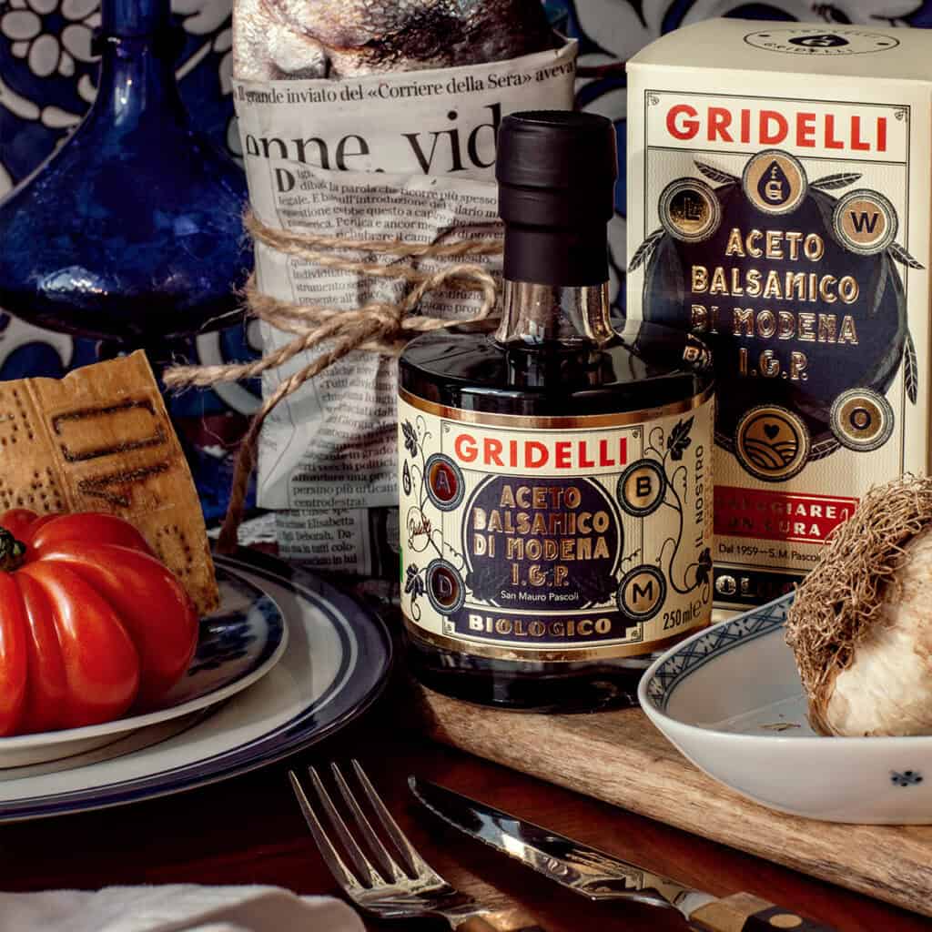 Italiensk ekologisk balsamvinäger från Gridelli – Aceto Balsamico Nero I.G.P. i miljö med fisk, tomat och parmesan