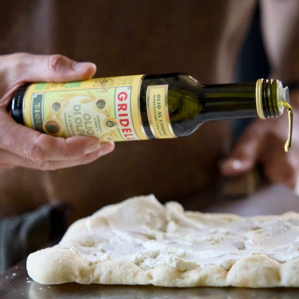 Gridelli Citronolivolja - ekologisk extra vergine olivolja smaksatt med citron, hälls över Pinsa.