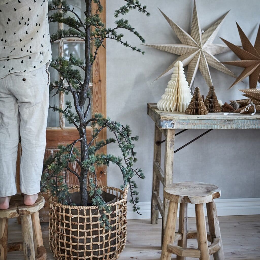 Pall PALLE i teakrot som del av julig inredning med gran, stjärnor och naturliga toner.