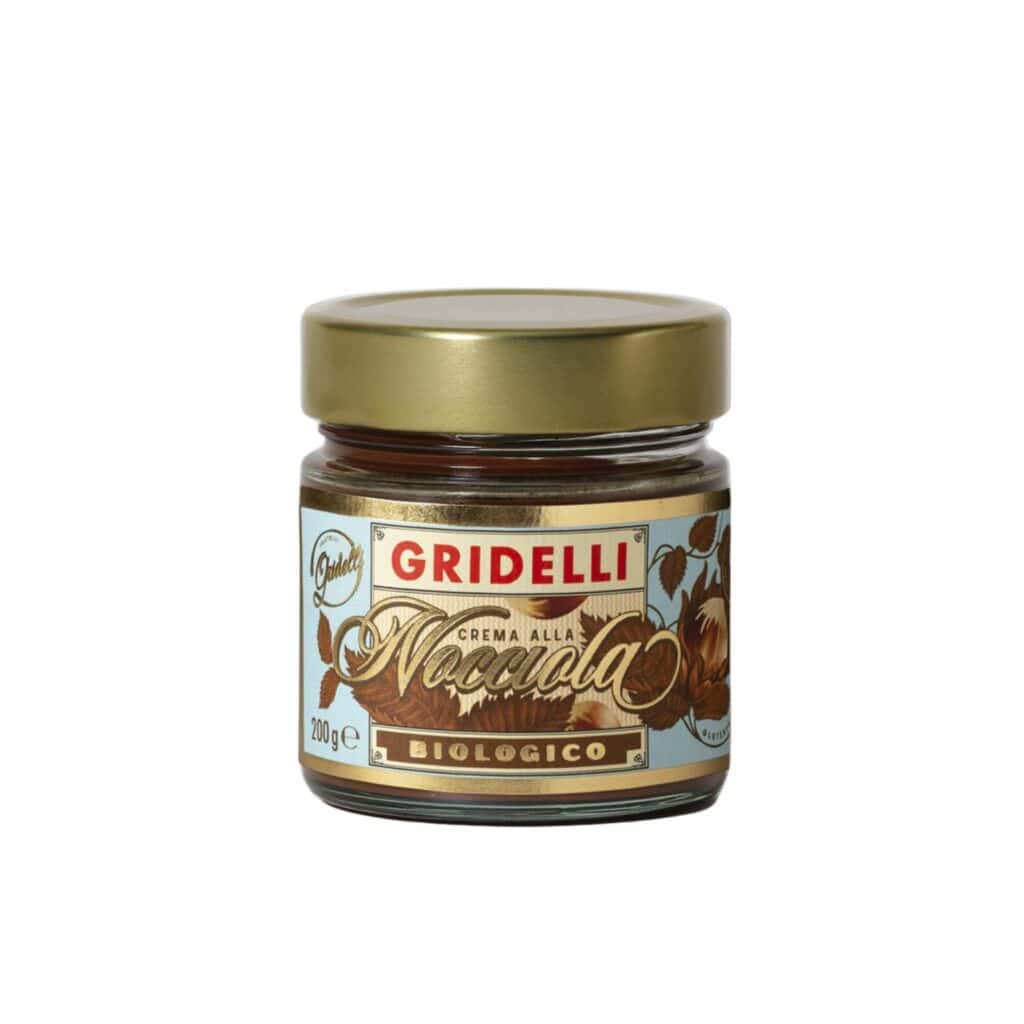 Glasburk med Gridelli Crema alla Nocciola, ekologisk hasselnötskräm med gyllene lock och elegant etikett, fotograferad mot en vit bakgrund.