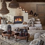 Vardagsrum dekorerat med Juni sittpuff i flätad makramé, elfenbensfärgad, och andra stilfulla inredningsdetaljer.