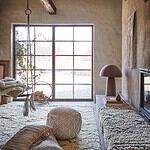 Inredningsmiljö med Juni sittpuff i flätad makramé, elfenbensfärgad, tillsammans med matchande dekorativa element.