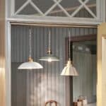 Taklampa Ingrid i antikvit plåt hänger i fönster tillsammans med glaslampor från Strömshaga