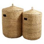 Två handflätade tvättkorgar i naturfärgad vattenhyacint med lock och bärhandtag, stående på vit bakgrund.