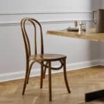 Klassisk bistrostol i björkträ vid matbord i ljust kök