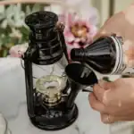 Lampolja från Strömshaga hälls i en svart fotogenlampa med tratt på ett marmorbord.