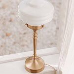 Närbild på VALTER bordslampa från Strömshaga, elegant design med mässingsfot och rund vit opalglasskärm.