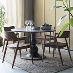 Runt bord Capri i brunt mangoträ från Wikholm Form, stylat med matchande trästolar, glas och tallrikar i en elegant och modern inredning.