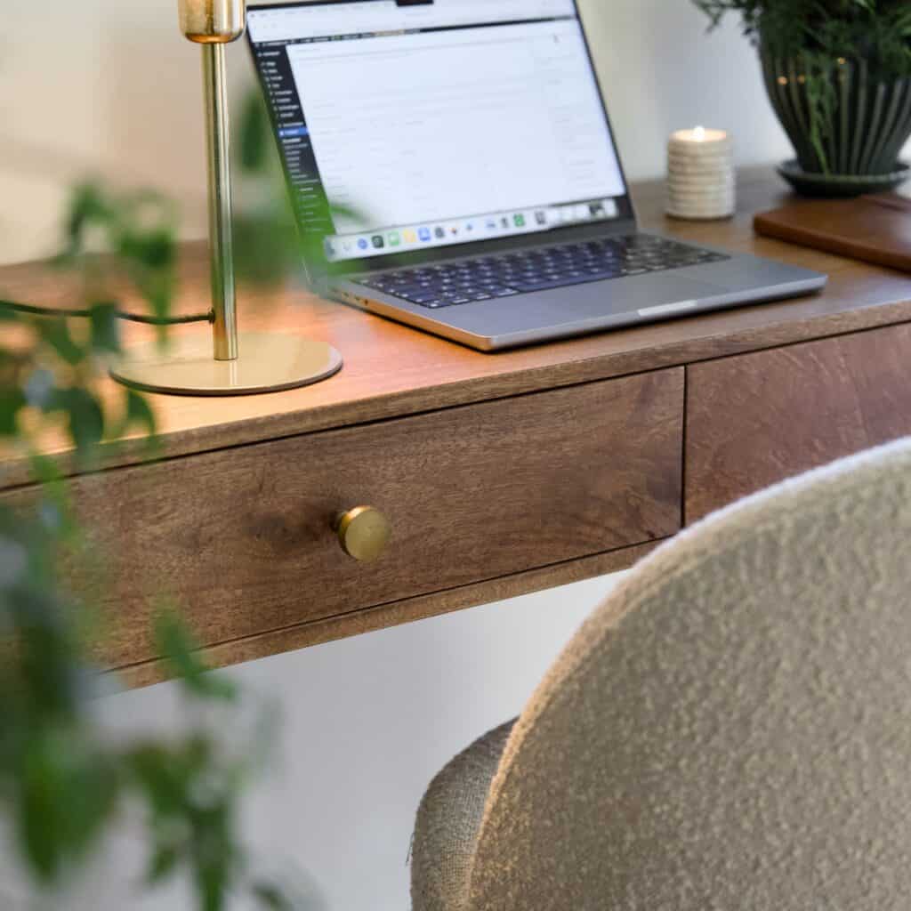 Konsolbord BETTON i mangotra med laptop, lampa och grona vaxter – detaljbild i varm hemmiljo.