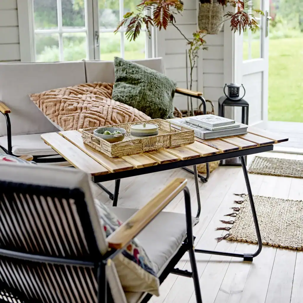 Hampton utebord från Bloomingville, placerat i en inbyggd veranda med mysiga sittplatser och eleganta dekorativa detaljer.