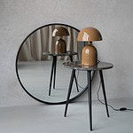 Brun bordslampa ROME från Wikholm Form, placerad på en hög med böcker på ett rustikt träbord, med en grön växt i bakgrunden.