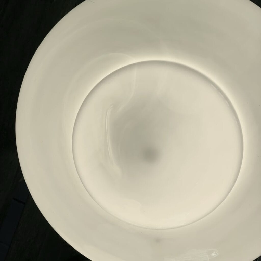 Närbild på opalglaset från insidan av taklampan VALTER som visar de naturliga skiftningarna och mönstren i glaset.