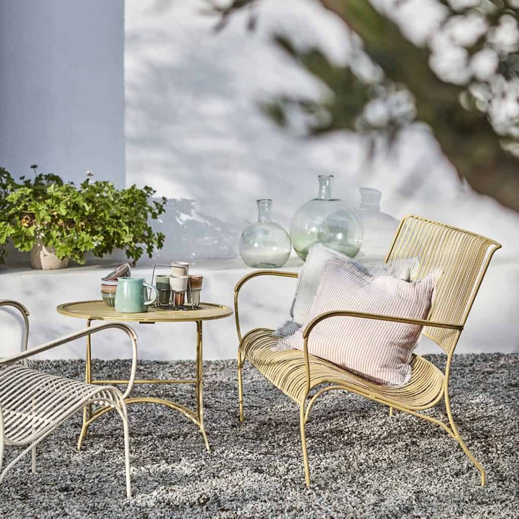 Kuddfodralet LINE i grön/vit på en uteplats, från Affari of Sweden.