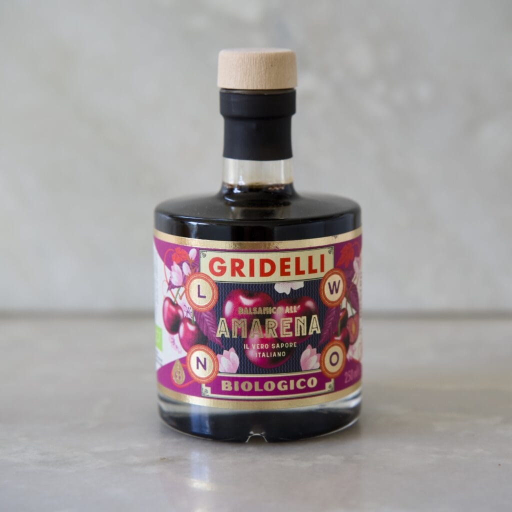 Flaska med Gridelli Balsamico Amarena på ett marmorbord.