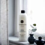 Mjukmedel DESIRE från Washologi i 750 ml-flaska vid fönster med naturligt ljus