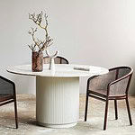 ERIE matbord dekorerat med vaser och grenar, omgiven av stolar med träram och nätliknande ryggstöd, i en ljus inomhusmiljö.