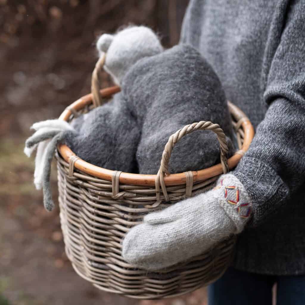 Alexia rottingkorg fylld med mjuka, gråa textilier, perfekt för vinterförvaring.