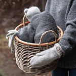 Alexia rottingkorg fylld med mjuka, gråa textilier, perfekt för vinterförvaring.