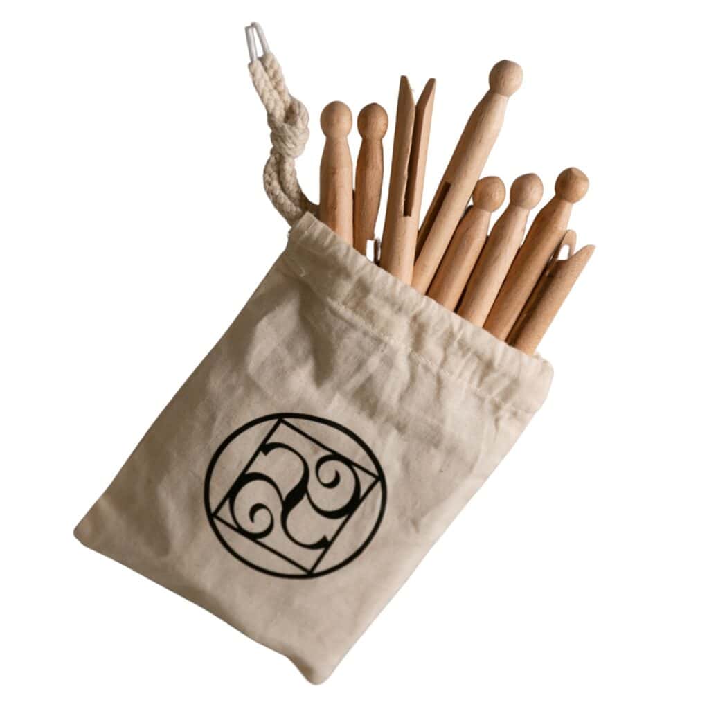 Gammaldags klädnypor i trä från Gröna Gredelina i en ekologisk bomullspåse, perfekta för hållbar tvätt.