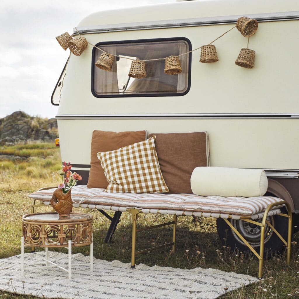 Ljusslinga i bambu från Madam Stoltz hängande på en husvagn, skapar en varm och rustik stämning utomhus.