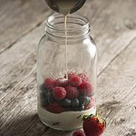 Glasburk från Kilner fylld med färska bär, medan grädde eller yoghurt hälls över, för en fräsch frukost eller mellanmål.