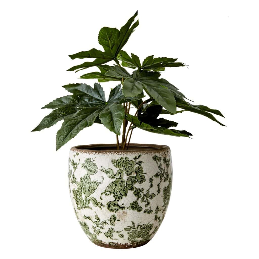 Victoria-krukan från Affari of Sweden, fylld med en grön växt. Krukan har en vit och grön design med blommigt mönster och en rustik, glaserad yta.