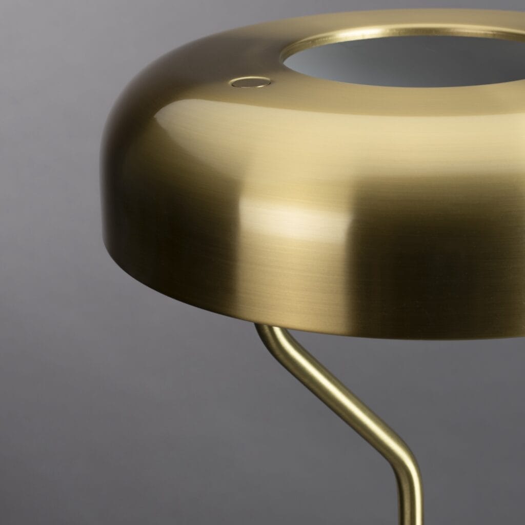 Närbild på den borstad mässingsskärmen hos bordslampan ECLIPSE från Dutchbone, som visar dess moderna och stilrena design.