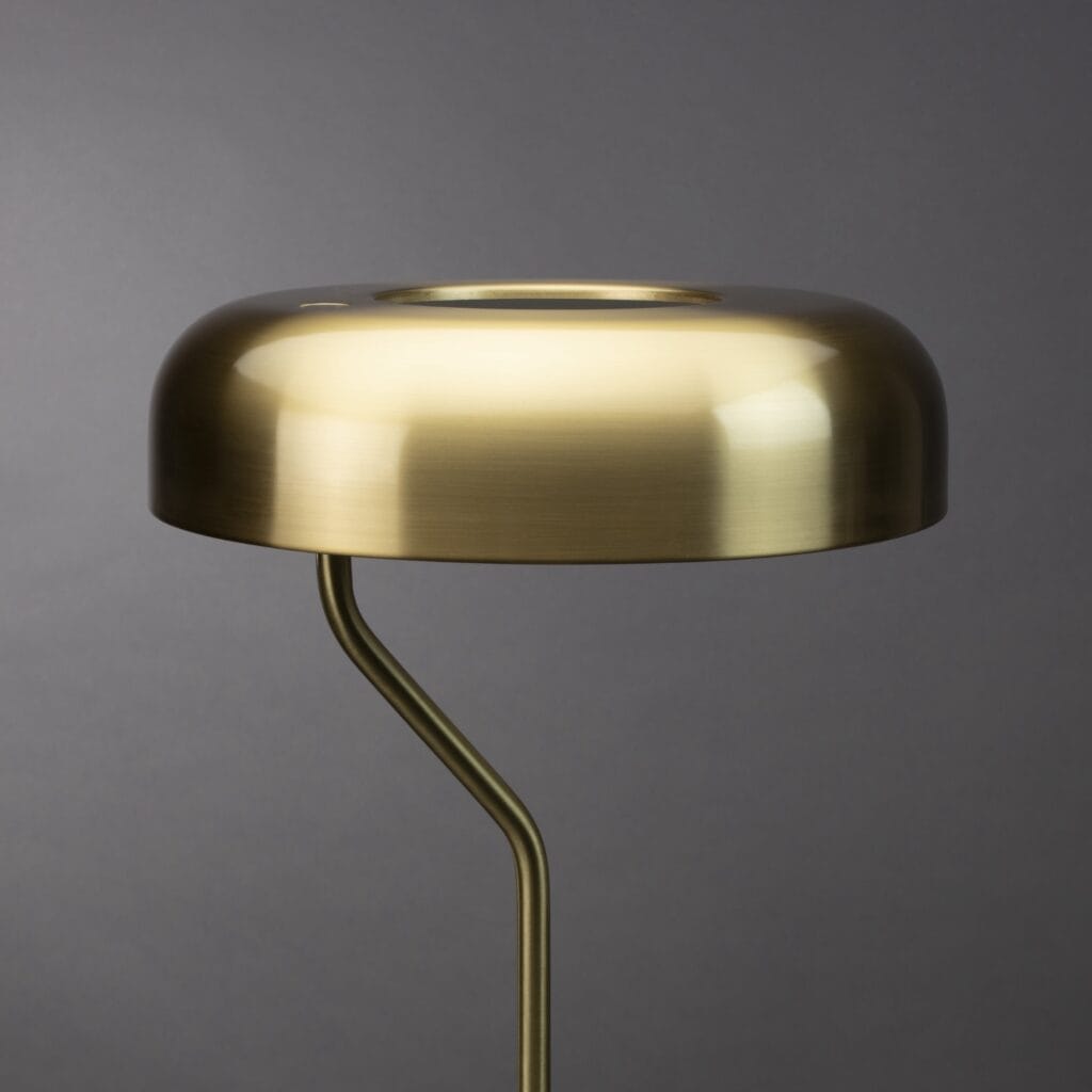 Närbild på lampskärmen hos bordslampan ECLIPSE i mässing från Dutchbone, som visar dess eleganta yta och moderna form.