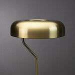 Närbild på lampskärmen hos bordslampan ECLIPSE i mässing från Dutchbone, som visar dess eleganta yta och moderna form.