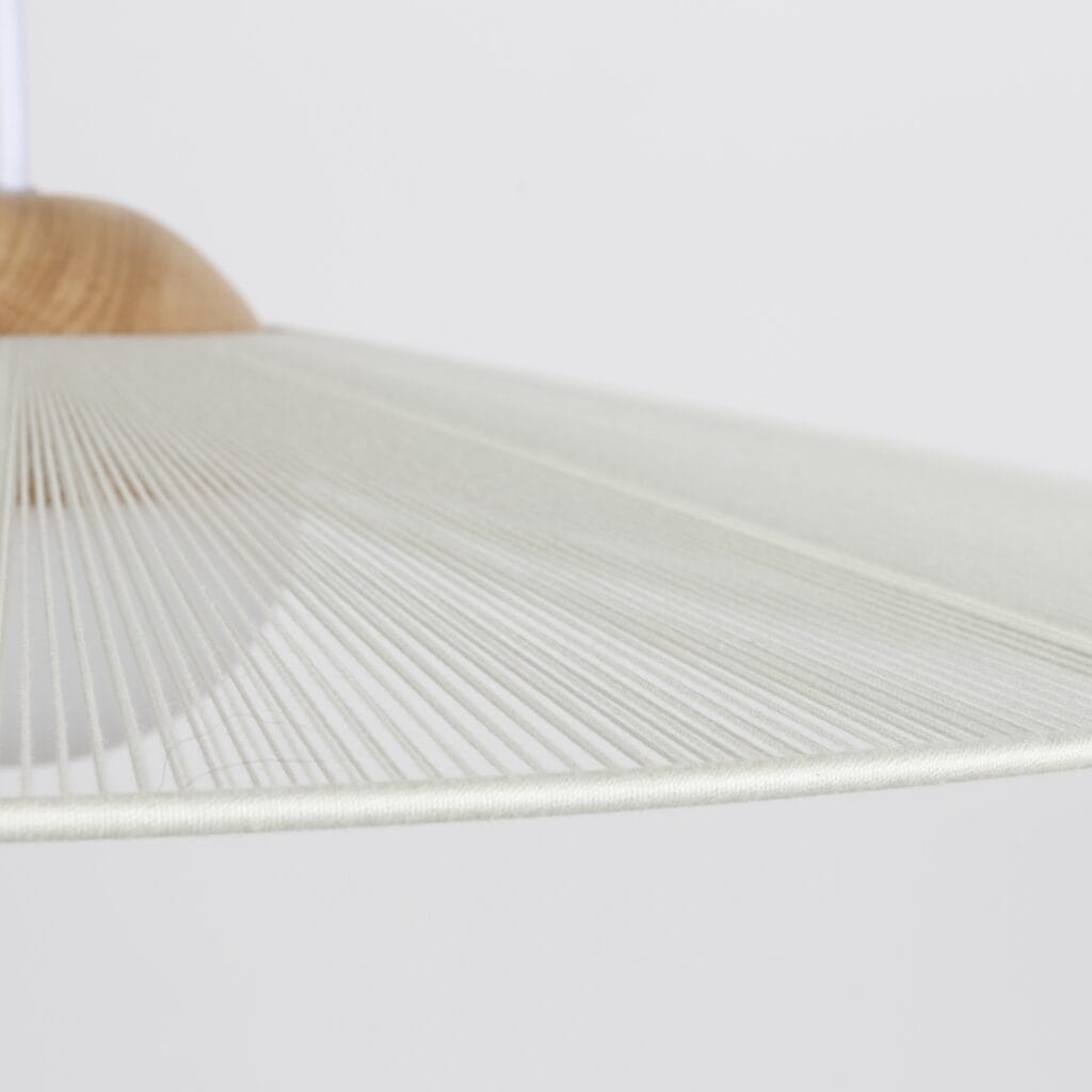 Närbild på kanten av taklampa Belle från Zuiver i beige, med detaljer som visar den fina strukturen i den spunna skärmen och trädetaljen på toppen.