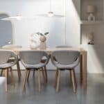 Två taklampor Belle från Zuiver i beige hänger över ett matbord i en minimalistisk inredning med naturliga trädetaljer och ljusa färger.