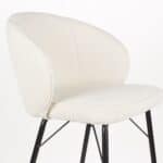 Närbild på Barstol JOA Vit med mjuk, vit klädsel i polyester och svarta metallben – stilren design med hög sittkomfort.