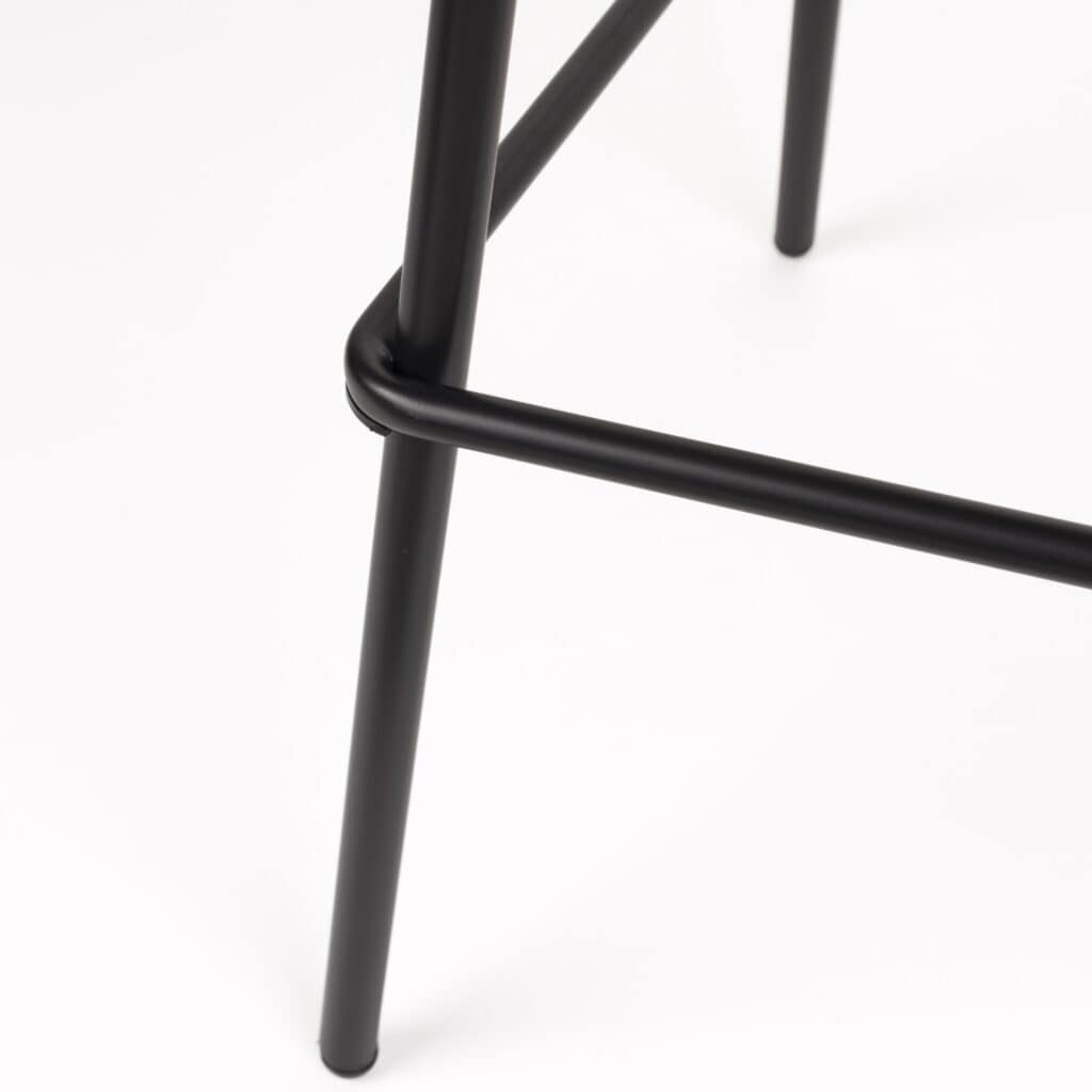 Närbild på de svarta metallbenen på Barstol JOA Vit – robust konstruktion med stilren design och praktisk fotstöd.