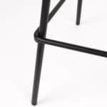 Närbild på de svarta metallbenen på Barstol JOA Vit – robust konstruktion med stilren design och praktisk fotstöd.