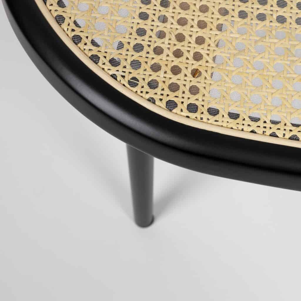 Närbild av loungefåtölj Spike från Zuiver – detaljbild av den flätade rottingen och den svarta ramen som ger fåtöljen dess eleganta och luftiga design.
