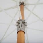 Närbild på det tiltbara mekaniska systemet under Gatsby parasoll från Brafab, med trästång och vita ribbor som stabiliserar skärmen.