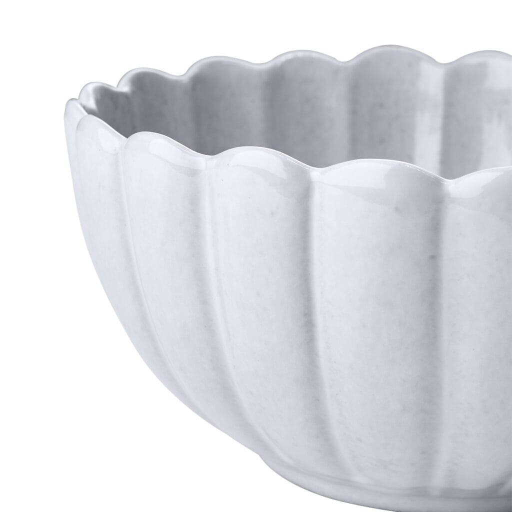 Närbild av Hulda-skålen i elfenbensvitt stengods från Affari of Sweden, som visar den vackert vågiga kanten och den glaserade ytan.