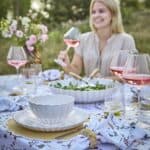 Somrig dukning med Hulda-servisen från Affari of Sweden i elfenbensvitt stengods, elegant kombinerad med blomstrande textilier och glas med rosévin.