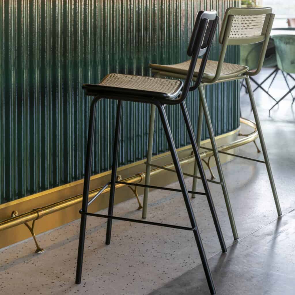 Barstolar i rotting med svart och olivgrön ram – Zuiver JORT placerade vid bardisk